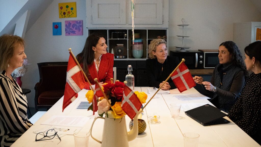 The Princess of Wales sitting at a table during a visit to Denmark.